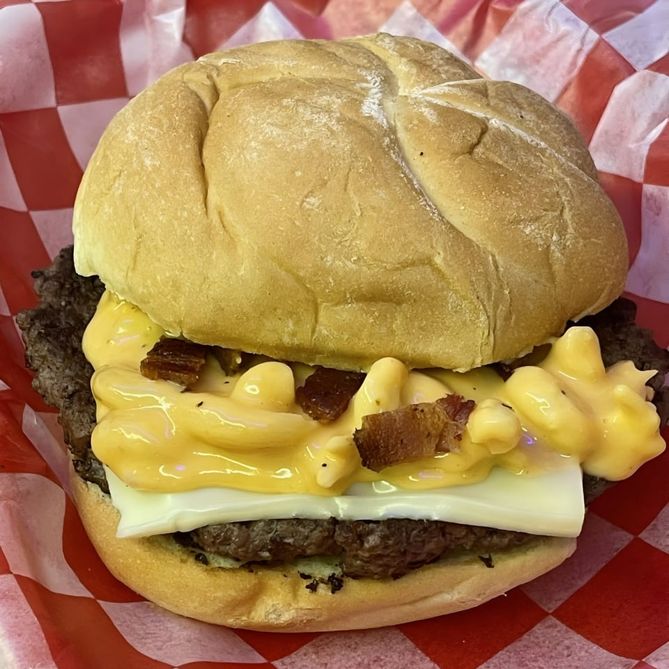 Route 10 Drive-In's burger with a beef patty, cheese, mac and cheese, and bacon bits.