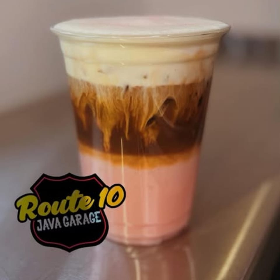 Layered drink with pink, brown, and white foam, featuring the Route 10 Java Garage logo.