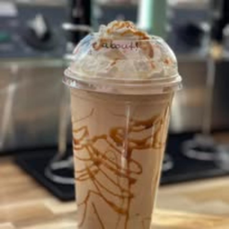 Route 10 Drive-In's caramel milkshake with whipped cream and a plastic dome lid.